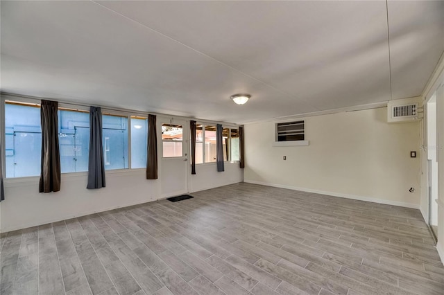 empty room featuring visible vents, baseboards, and wood finished floors