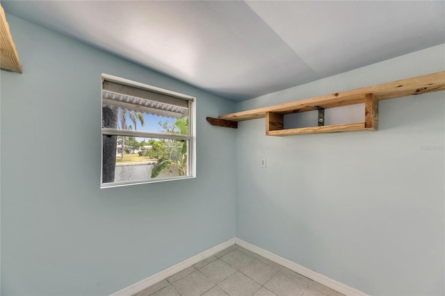 unfurnished room with baseboards and light tile patterned flooring
