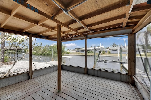 unfurnished sunroom with a water view, a residential view, and a wealth of natural light