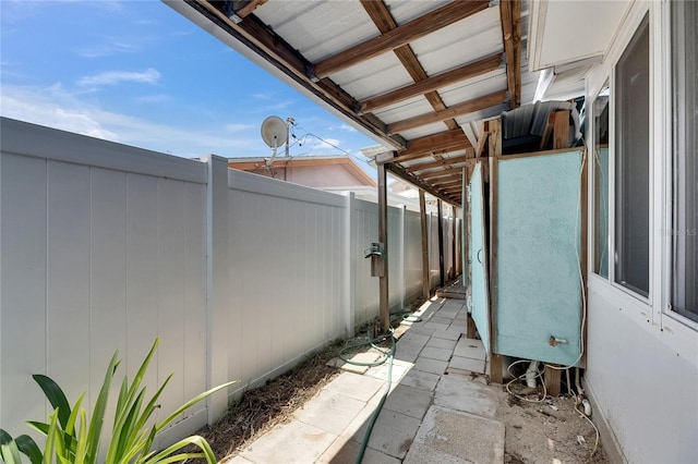 view of side of home featuring fence and stucco siding