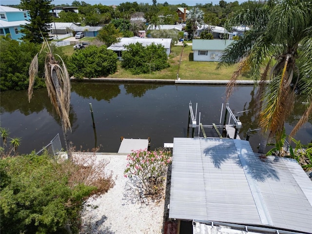 dock area with a residential view, boat lift, and a water view