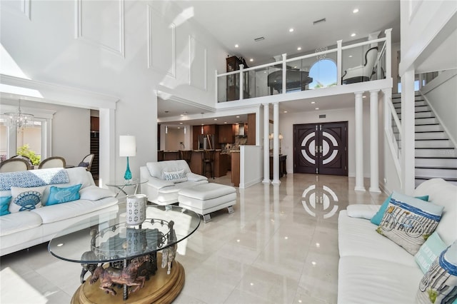 2233 Donato Dr, Belleair Beach, FL 33786 - tiled living room featuring stairs, a towering ceiling, ornate columns, visible vents, and recessed lighting