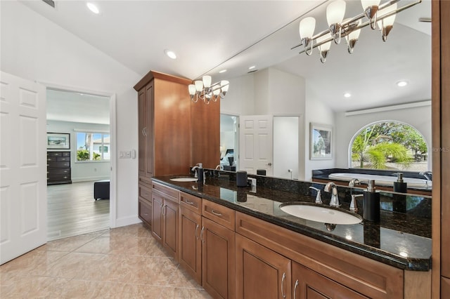 2233 Donato Dr, Belleair Beach, FL 33786 - full bath with a notable chandelier, double vanity, a sink, and vaulted ceiling