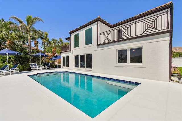 2233 Donato Dr, Belleair Beach, FL 33786 - rear view of property with a balcony, a patio area, stucco siding, and an outdoor pool