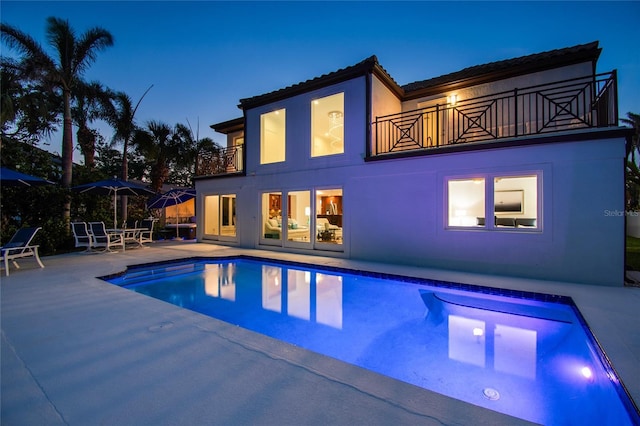 2233 Donato Dr, Belleair Beach, FL 33786 - back of house featuring a balcony, a patio, an outdoor pool, and stucco siding