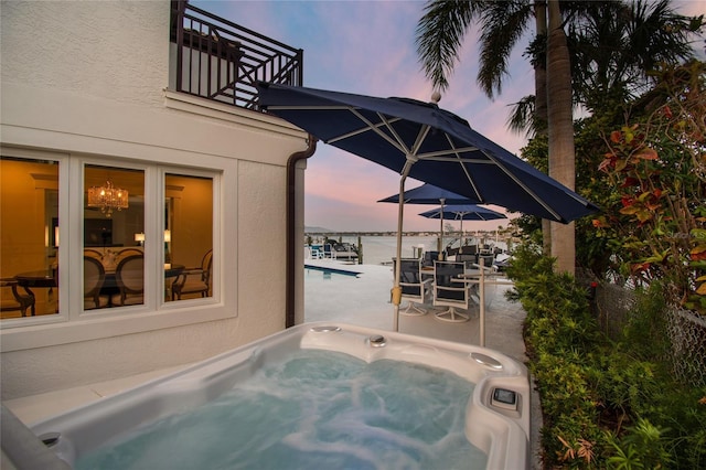 2233 Donato Dr, Belleair Beach, FL 33786 - pool at dusk with a hot tub, a water view, a patio, and a pool