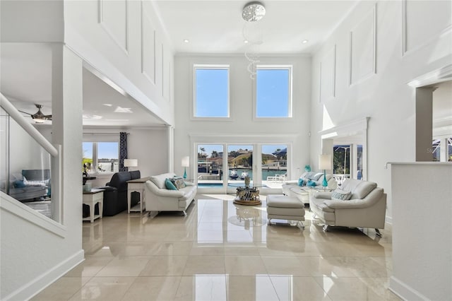 2233 Donato Dr, Belleair Beach, FL 33786 - living room with light tile patterned floors, baseboards, a ceiling fan, and a high ceiling