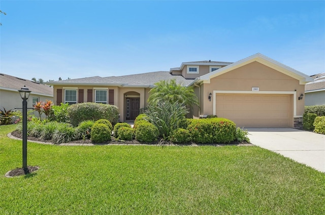 view of front of property featuring stucco siding, driveway, a front lawn, and a garage