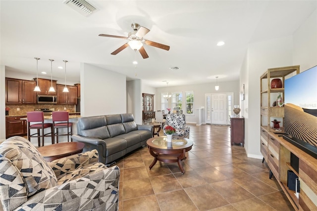 living area featuring recessed lighting, dark tile patterned floors, baseboards, visible vents, and a ceiling fan