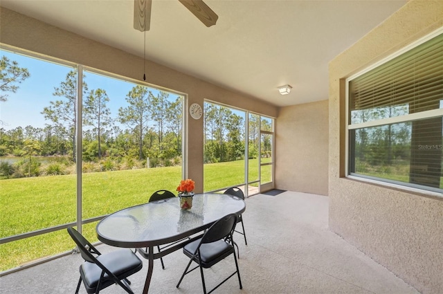 sunroom / solarium with a ceiling fan and outdoor dining area