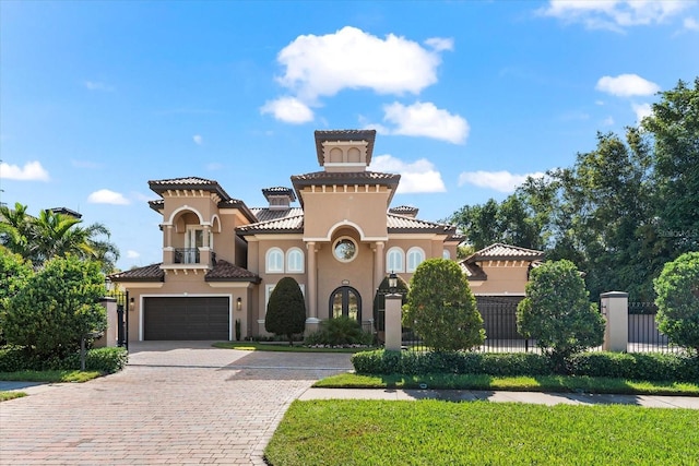 1600 Magnolia Rd, Belleair, FL 33756 - mediterranean / spanish house featuring decorative driveway, stucco siding, an attached garage, and a tiled roof