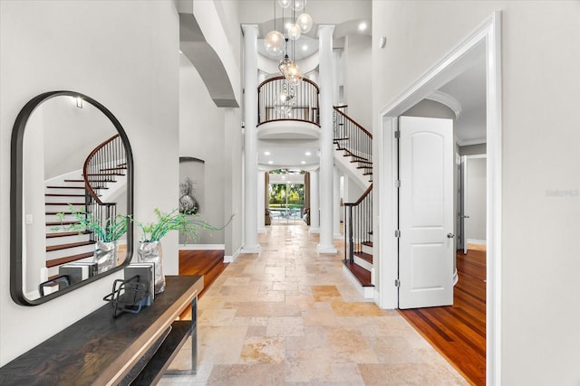 1600 Magnolia Rd, Belleair, FL 33756 - foyer entrance featuring stairway, stone tile flooring, a towering ceiling, baseboards, and a chandelier