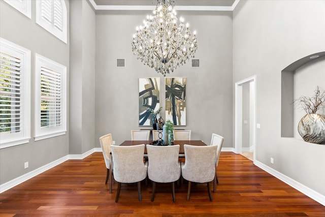 1600 Magnolia Rd, Belleair, FL 33756 - dining room featuring a high ceiling, wood finished floors, a chandelier, and baseboards