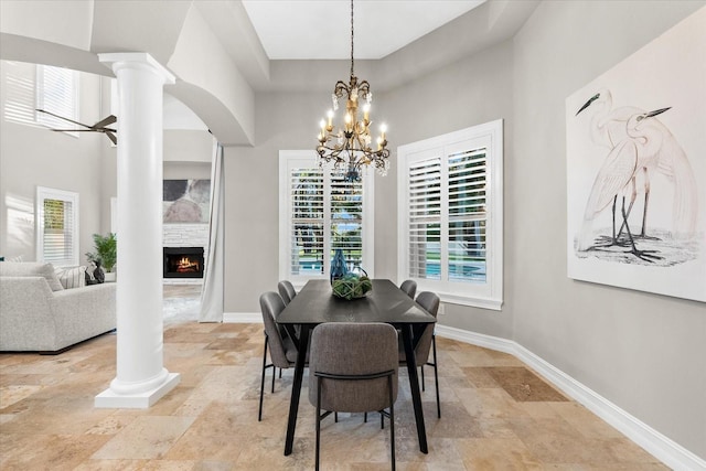 1600 Magnolia Rd, Belleair, FL 33756 - dining area featuring stone tile floors, decorative columns, a high ceiling, baseboards, and a chandelier