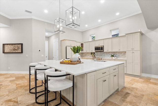 1600 Magnolia Rd, Belleair, FL 33756 - kitchen featuring stainless steel microwave, stone tile floors, backsplash, crown molding, and a spacious island