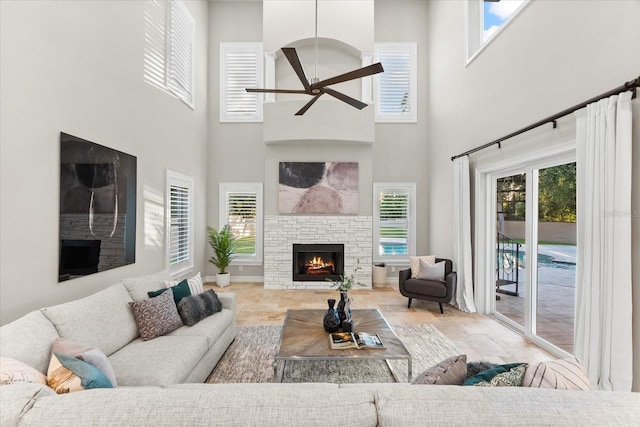 1600 Magnolia Rd, Belleair, FL 33756 - living area featuring a stone fireplace, a towering ceiling, and ceiling fan