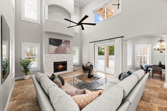 1600 Magnolia Rd, Belleair, FL 33756 - living area with a chandelier, a stone fireplace, a towering ceiling, a ceiling fan, and baseboards