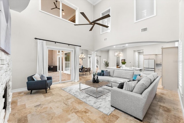1600 Magnolia Rd, Belleair, FL 33756 - living area with arched walkways, a chandelier, a high ceiling, decorative columns, and ceiling fan