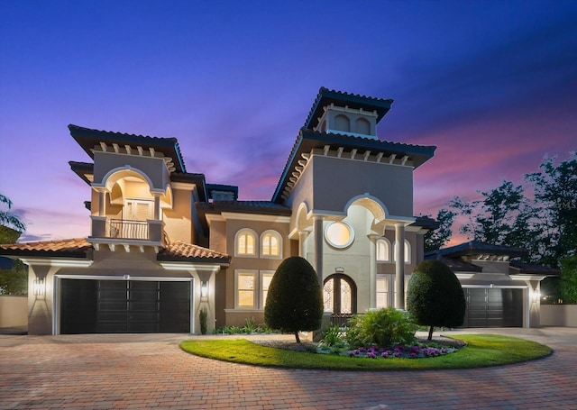 1600 Magnolia Rd, Belleair, FL 33756 - mediterranean / spanish home featuring a balcony, decorative driveway, stucco siding, a tiled roof, and an attached garage