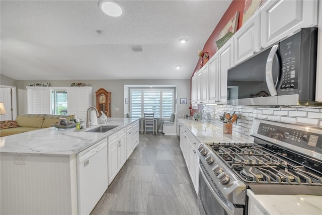 kitchen featuring stainless steel gas range oven, white cabinets, dishwasher, a sink, and visible vents