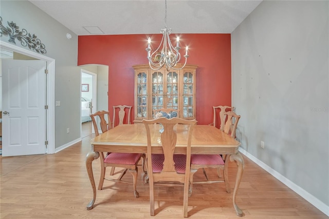 dining room featuring baseboards, a notable chandelier, and light wood-style flooring