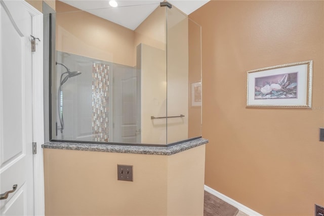 full bathroom featuring a walk in shower and baseboards