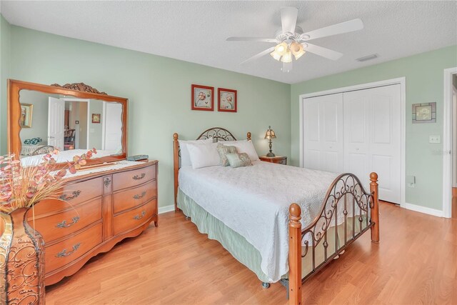bedroom featuring baseboards, visible vents, a closet, and light wood finished floors