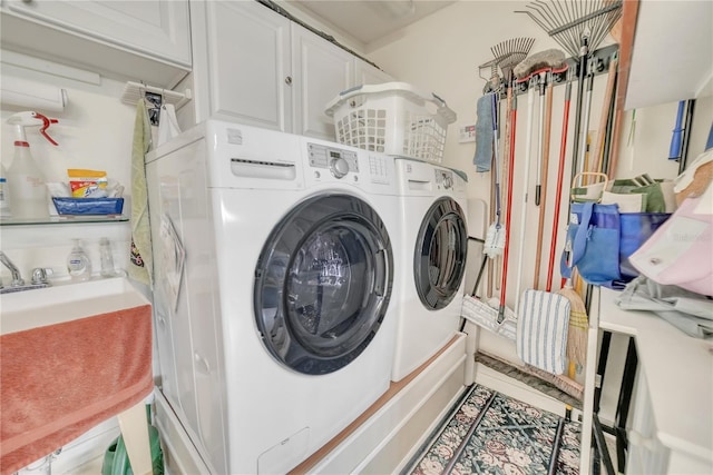 clothes washing area featuring independent washer and dryer and cabinet space