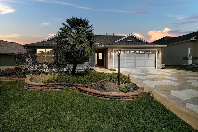 ranch-style house with a shingled roof, a front lawn, driveway, and an attached garage