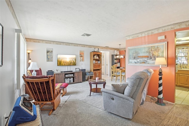 living area featuring a textured ceiling, visible vents, a chandelier, and light carpet