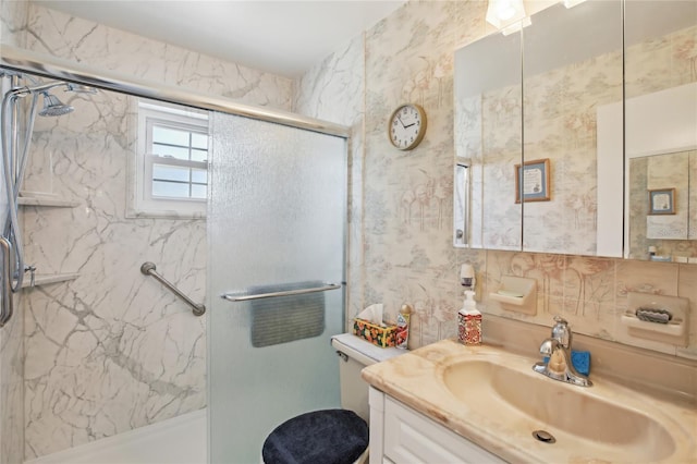 bathroom featuring toilet, vanity, and a marble finish shower