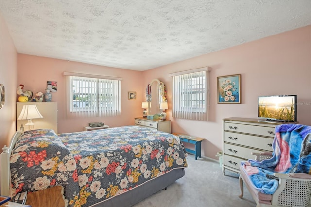 carpeted bedroom with a textured ceiling, baseboards, and multiple windows