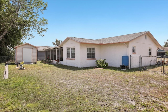 back of house with fence, a storage shed, a gate, and a sunroom
