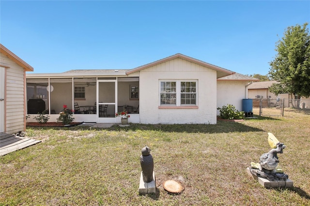 back of house featuring a gate, fence, a yard, and a sunroom