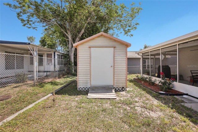 view of shed with a sunroom and fence