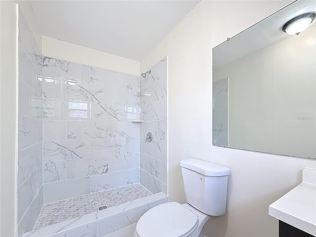 full bath featuring a tile shower, toilet, and vanity