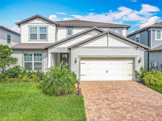17683 Ramble On Way, Land O Lakes, FL 34638 - traditional-style house featuring a shingled roof, an attached garage, stucco siding, and decorative driveway