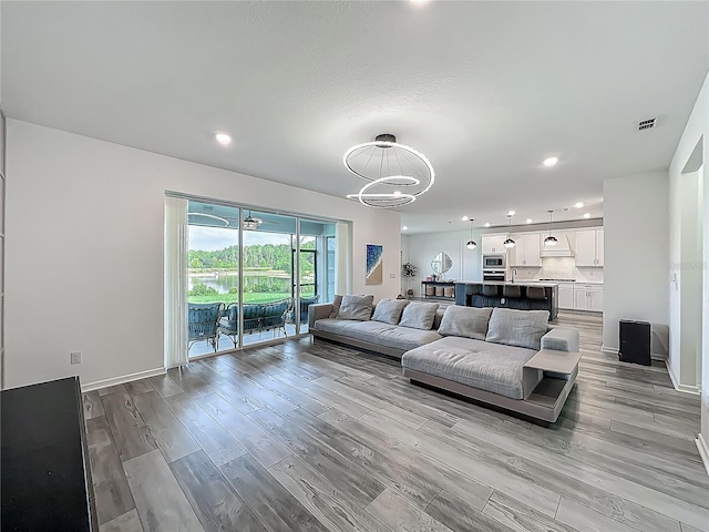 17683 Ramble On Way, Land O Lakes, FL 34638 - living room with an inviting chandelier, recessed lighting, light wood-style flooring, and visible vents