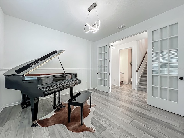 17683 Ramble On Way, Land O Lakes, FL 34638 - sitting room featuring french doors, visible vents, wood finished floors, baseboards, and stairs