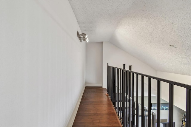2400 Feather Sound Dr Unit 735, Clearwater, FL 33762 - hallway featuring baseboards, vaulted ceiling, a textured ceiling, and wood finished floors