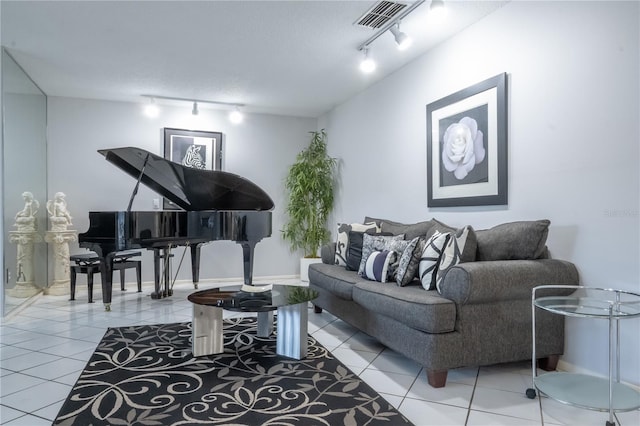 living area featuring tile patterned flooring, visible vents, and rail lighting