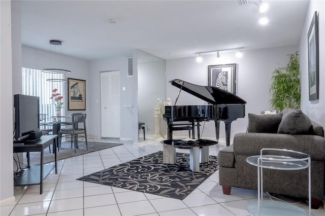 sitting room with rail lighting, visible vents, tile patterned floors, and baseboards