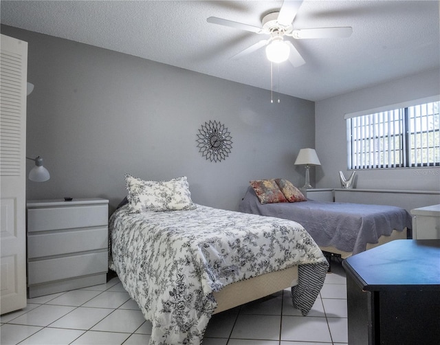 bedroom featuring light tile patterned floors, a textured ceiling, and a ceiling fan