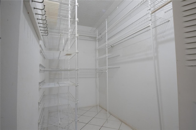 walk in closet with tile patterned floors