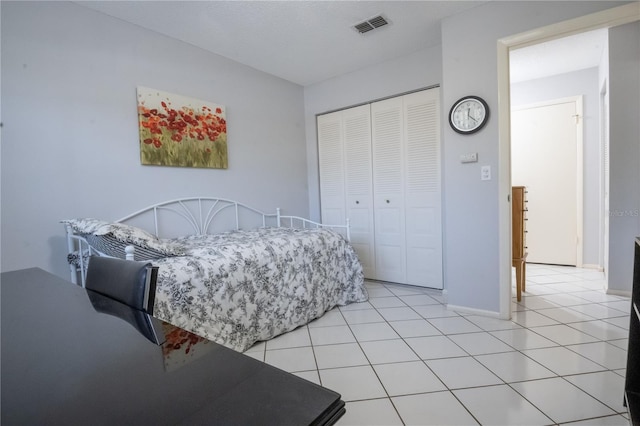 bedroom featuring light tile patterned floors, a closet, visible vents, and baseboards