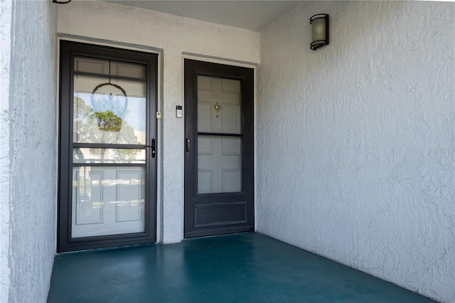 view of exterior entry with stucco siding