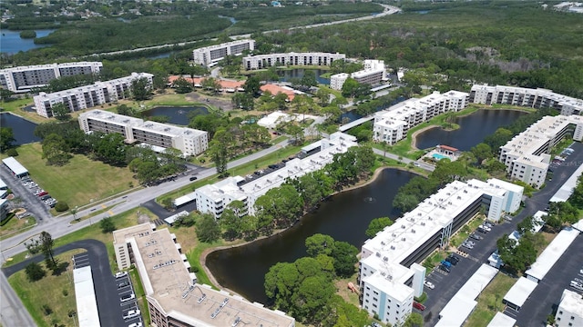 drone / aerial view featuring a water view and a wooded view