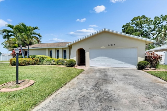 single story home featuring a front yard, driveway, a garage, and stucco siding