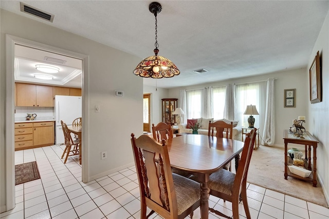 dining room featuring light tile patterned flooring, visible vents, and baseboards