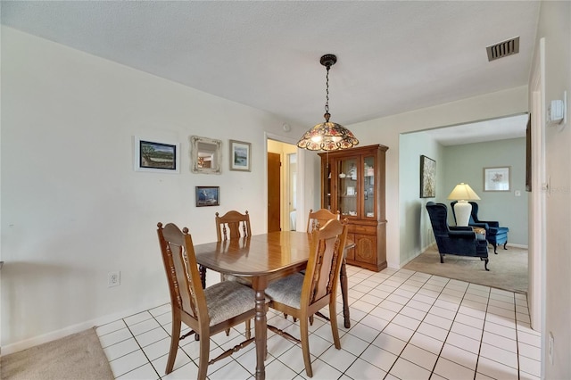 dining area featuring light tile patterned flooring, visible vents, light colored carpet, and baseboards